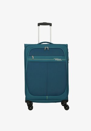 Valise en tissu turquoise avec une finition lisse, un compartiment principal à double zip, une poche avant, et quatre roues noires pour la mobilité.