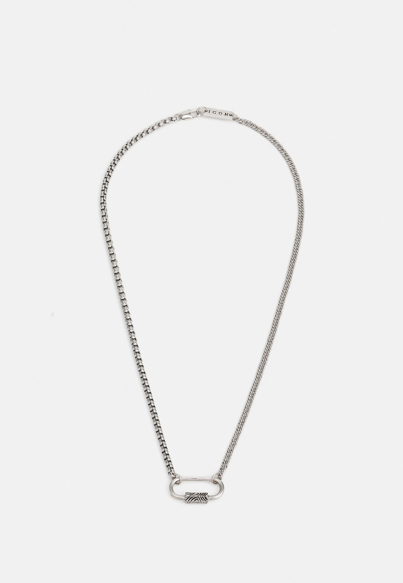 Collier en chaîne en argent avec un fermoir ovale lisse et un accent texturé. Les maillons sont uniformes et polis, créant une apparence élégante.