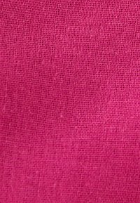 Tela rosa con un patrón texturizado y tejido. El material parece ligero y transpirable, adecuado para ropa o tapicería.