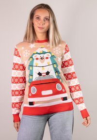 Roter und beige gestrickter Pullover mit einem Bären in einem Auto, der einen Weihnachtsbaum transportiert. Die Ärmel zeigen abwechselnde Muster mit Schneeflocken und roten Akzenten.