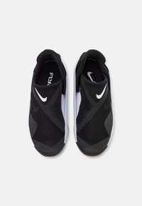 Μαύρα και άσπρα Nike παπούτσια slip-on με πλεκτά πάνελ, υφή στη σόλα και έντονο καμπύλο σχέδιο με άσπρο λογότυπο.
