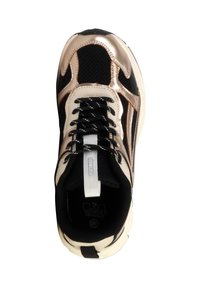 Zapatilla negra y dorada metálica con suela blanca y cordones negros, vista desde arriba.