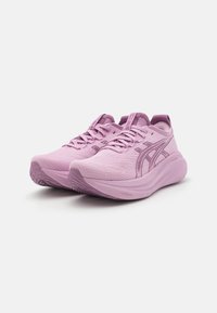 Hellrosa Sportschuhe mit strukturiertem Obermaterial, ausgestattet mit Schnüren und einer gepolsterten Sohle. Dezent an der Seite angebrachter Logo und ein leicht geschwungenes Design.