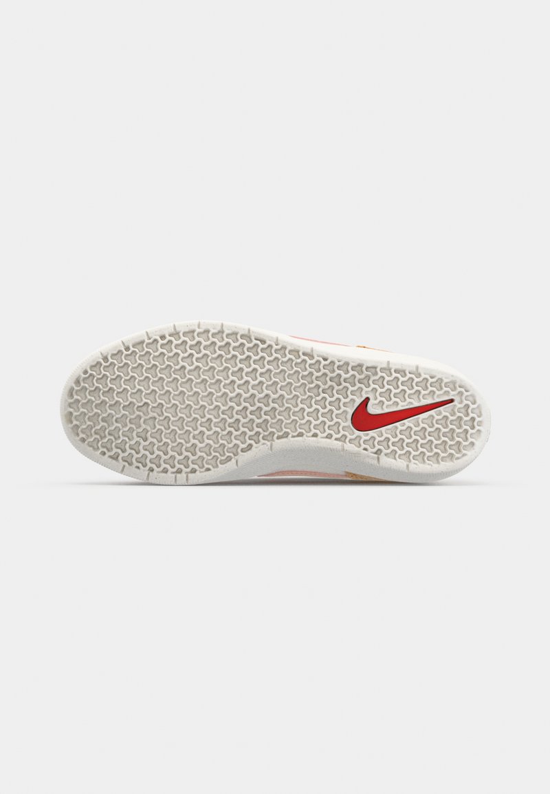 Suela de zapato Nike con superficie de goma texturizada, con una base blanca y el logo de Nike en rojo. El patrón incluye pequeñas formas de estrella para mejorar la tracción.