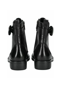 Botas de tobillo de cuero negro con cremallera lateral, correa ajustable con hebilla y suela de goma texturizada. Acabado suave con un diseño elegante.