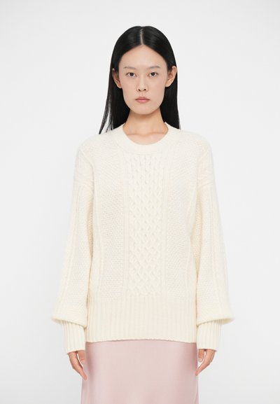 Pull en tricot couleur crème avec un motif de câble texturé, des poignets côtelés et un col rond. Coupe décontractée et design épais.