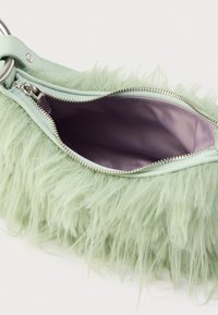 Torebka z miętowozielonym futerkiem syntetycznym, zamkiem błyskawicznym, srebrnym okuciem i gładkim fioletowym wnętrzem. Charakteryzuje się zaokrąglonym kształtem.