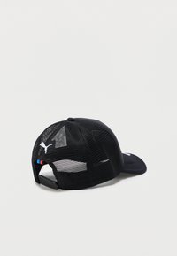 Μαύρο καπέλο baseball Puma με μαύρο διχτυωτό ύφασμα και ρυθμιζόμενο κούμπωμα snapback, λευκό λογότυπο Puma και μικρές μπλε και κόκκινες ρίγες κοντά στο κούμπωμα.