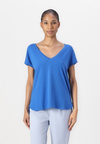 T-shirt blu in cotone con scollo a V, maniche corte, vestibilità rilassata e orlo leggermente curvo. Tessuto morbido con un sottile motivo mélange.