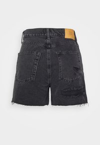 Svarta denimshorts med fransad nederkant, slitna detaljer och två bakfickor. Har en brun läderetikett med "BDG" vid midjan.