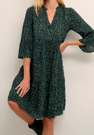 Grünes gemustertes Kleid mit V-Ausschnitt und dreiviertellangen Ärmeln. Verfügt über einen gestuften Saum und eine lockere Passform, gefertigt aus leichtem Stoff.