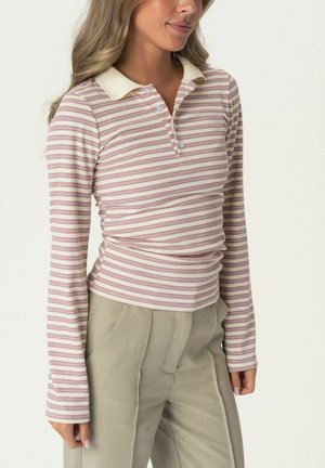 Langarm polohemd met lichtroze en crèmekleurige horizontale strepen, voorzien van een crèmekleurige kraag en knopenlijst, gecombineerd met lichtgrijze trousers.
