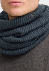 Tumehall villane sall ribakudumisega, lahtistes voltides, küljes väike kolmnurkne logomärk.