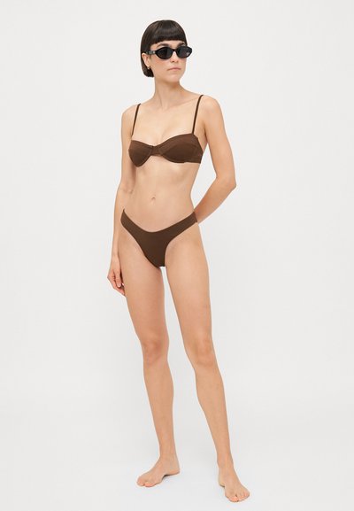 Brown bikini set featuring a padded bralette top with thin straps and matching low-rise bikini bottoms. The material appears smooth and matte.