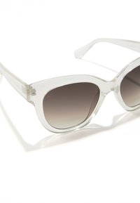 Ochelari de soare din plastic transparent cu formă cat-eye, cu lentile în degrade închise la culoare și strălucire subtilă în rama. Accente argintii pe brațe.