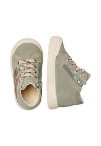 Un paio di scarpe da ginnastica verdi per bambini con lacci beige, zip laterale e suole in gomma beige su sfondo bianco.