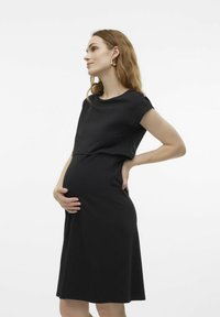 Robe de maternité noire en tissu doux, avec un corsage ajusté, une jupe évasée, des manches courtes et un décolleté arrondi.