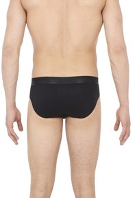 Slip neri da uomo con una cintura elastica morbida. Il tessuto sembra morbido e aderente, con un design minimalista e senza motivi visibili.