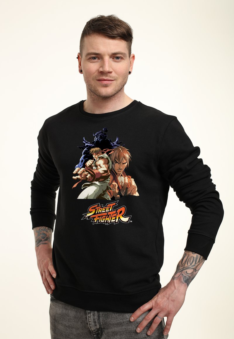 Felpa nera con una grafica di tre personaggi della serie "Street Fighter"; tessuto morbido, collo tondo, maniche lunghe.