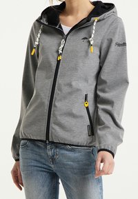 Veste sweat grise avec capuche noire. Comprend des accents de cordon jaune, des poches latérales zippées et un logo sur la poitrine. Texture lisse.