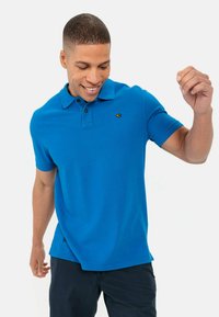 Niebieska koszulka polo z mieszanki bawełny, z klasycznym kołnierzykiem, krótkimi rękawami i małym logo na piersi. Casualowy krój.