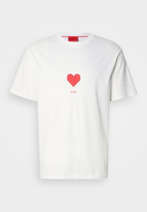 Valge puuvillane t-särk, mille keskel on punane südamegraafika. Brändinimi "HUGO" on südame all trükitud lihtsas kirjas.