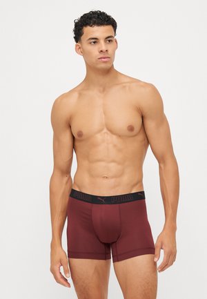 Maroon boxers with a black elastic waistband featuring a logo. Material appears soft and stretchy, with a close-fitting design.