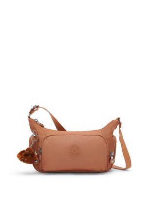 Kompakte hellbraune Crossbody-Tasche mit mehreren Reißverschlusstaschen und einem kleinen Plüschaffen-Schlüsselanhänger an der Seite.