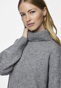 Ανοιχτό γκρι, πλεκτό πουλόβερ με ψηλό ριγωτό γιακά και ριγωτά μανίκια. Μαλακή υφή με εμφανείς ραφές. Κατάλληλο για καθημερινή χρήση.