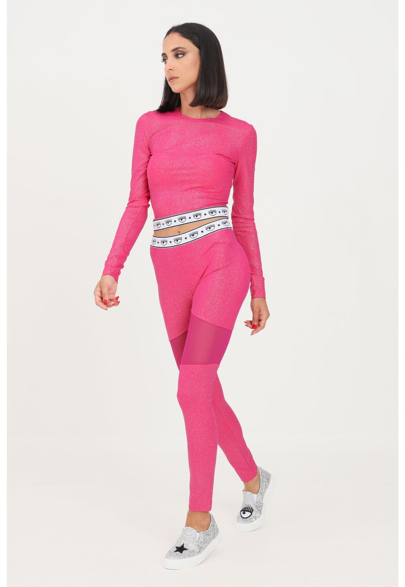Rosa Langarmoberteil mit Glitzer-Finish, kombiniert mit passenden Leggings mit Netzeinsatz. Akzentuiert mit einem gemusterten Taillenbund und silbernen Sneakers.
