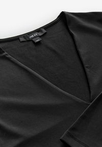 Schwarzes V-Ausschnitt-Top aus glattem, elastischem Stoff. Hat ein einfaches Design mit kurzen Ärmeln und minimalen Nähten. Etikett sichtbar.