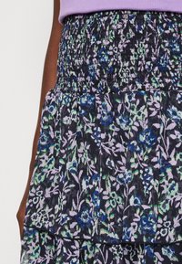 Květinová sukně s volány a nařaseným pasem v tmavých barvách. Obsahuje zelené a modré květinové vzory na černém pozadí. Lehký materiál.