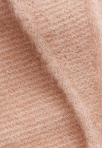 Tissu en mélange de laine pêche doux avec un motif de tricot texturé, présentant une légère douceur et des fibres visibles pour un détail supplémentaire.