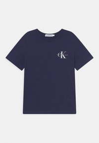 Tumman sininen puuvillapaita, jossa on pyöreä kaula-aukko, lyhyet hihat ja etupuolella logo, jossa lukee "Calvin Klein Jeans" sekä tyylitelty "K."