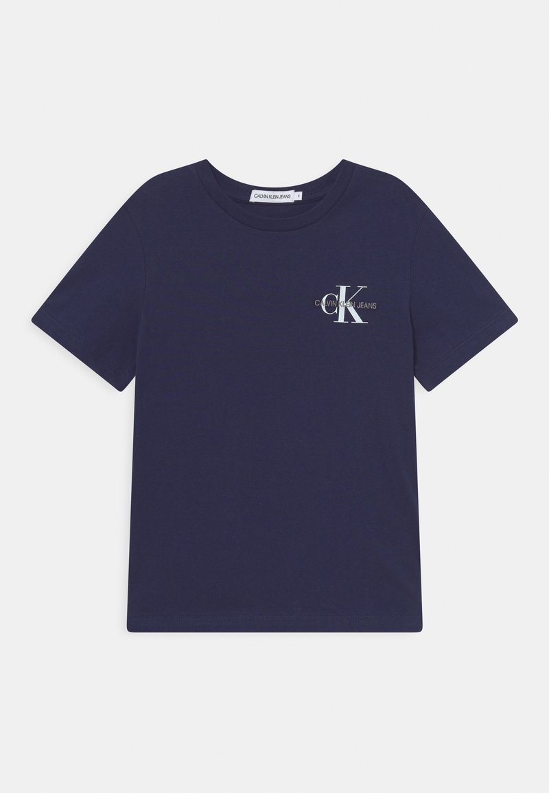 Tumman sininen puuvillapaita, jossa on pyöreä kaula-aukko, lyhyet hihat ja etupuolella logo, jossa lukee "Calvin Klein Jeans" sekä tyylitelty "K."