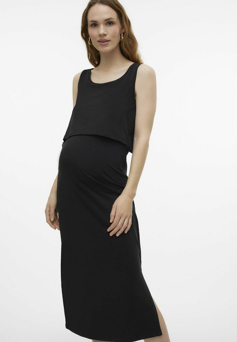 Black maternity dress with a layered tank top design and fitted midi skirt. Smooth texture, round neckline, and side slit detail.