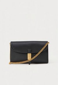 Black leather clutch with a gold chain strap, rounded flap closure, and a decorative clasp featuring horizontal grooves. Smooth texture.