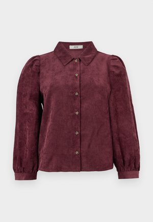 Burgundia värvi corduroy särk kraega, nööpidega ees, pikad puhvärvid ja elastsete mansettidega. Ühtlane vertikaalne tekstuurimuster kogu särk.