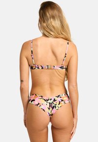 Floral bikini in black with pink, orange, and green patterns. Features thin straps and a V-shaped back. Made from stretchy swimwear material.