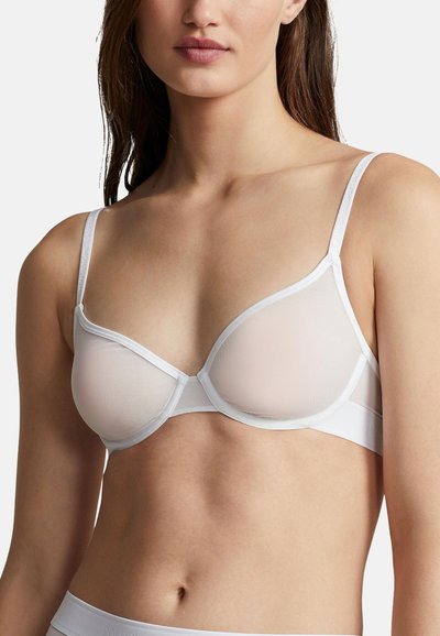 Bílá síťovaná podprsenka s kosticemi, průsvitnými košíčky a nastavitelnými ramínky. Vyznačuje se měkkou tkaninou a minimalistickým designem.