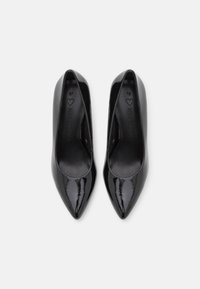 Tacones altos de charol negro con un diseño de punta afilada, textura suave y estilo minimalista. Talla 37 marcada en el interior.