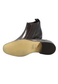 Stivale alla caviglia in pelle nera con pannelli elastici laterali, punta arrotondata, design elegante e finitura liscia. Presenta una suola di colore chiaro.