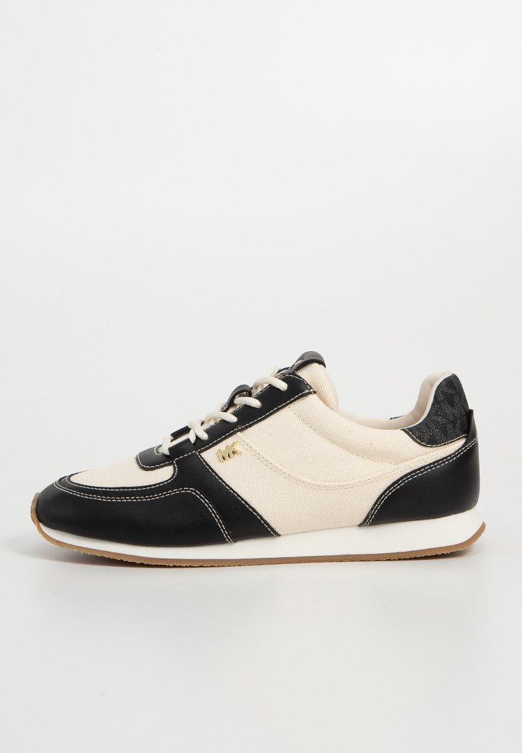 Herrskor i sneakersstil med en beige kanvasöverdel och svarta läderdetaljer, rund tådesign, vit sömnad och gummisula.