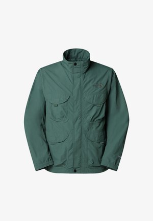 Vihreä ulkoilutakki, joka on valmistettu kevyestä materiaalista. Takissa on korkea kaulus, useita etutaskuja ja joustavat hihansuut. Brändin logo rinnassa.