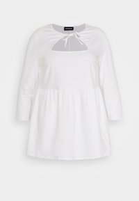 Vestido de algodão branco com mangas longas, decote redondo, recorte em forma de olho-chave e detalhe de laço ajustável no pescoço; cintura franzida, corte solto.