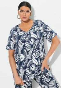 Námořnický modrý top s krátkým rukávem a bílým květinovým a listovým potiskem, design s výstřihem do V, volný střih, lehký materiál, v kombinaci s odpovídajícími kalhotami.