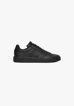 Zapatilla Adidas negra de corte bajo con cordones delanteros, tres franjas laterales y suela de goma mostrada de perfil sobre fondo blanco.