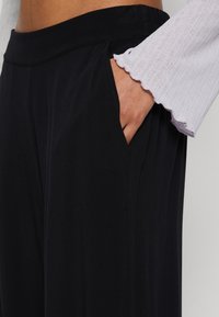 Vero Moda Petite VMEASY WIDE PANTS LEO PRINT - Pantalon classique - black