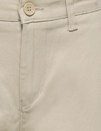 Beige bomuldsbukser med en sidelomme og to-klik lukning. Stoffet har en glat tekstur med subtile syninger.