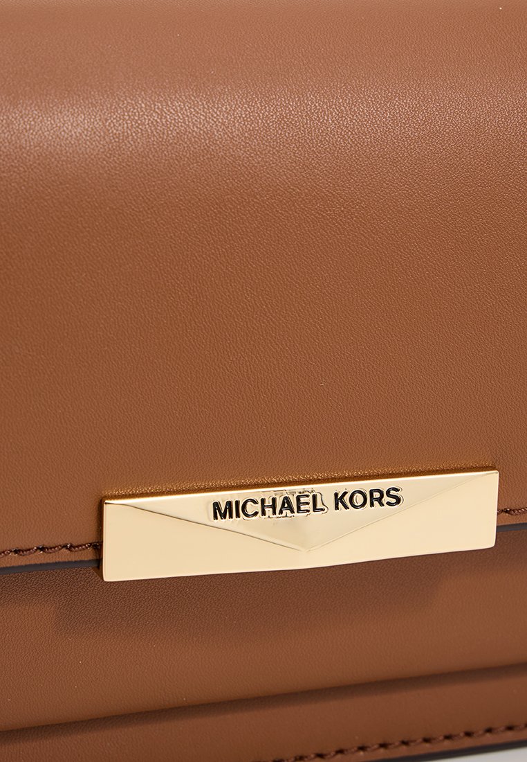 Portefeuille en cuir brun avec quincaillerie dorée et une plaque logo rectangulaire avec un texte en relief, mettant en avant une texture lisse et un design épuré.